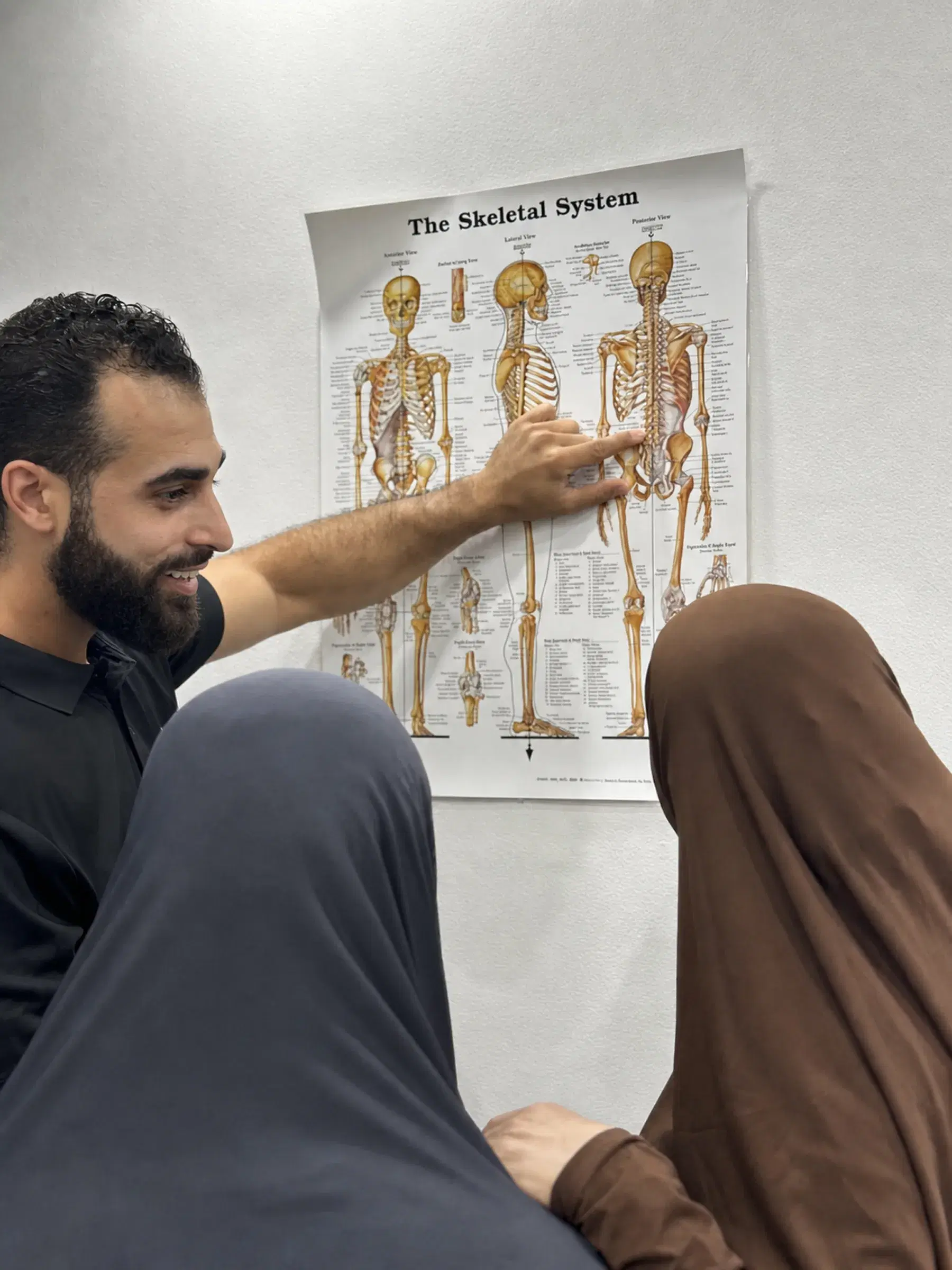 Dr Laith Musallam explaining a spinal chart to a patient.